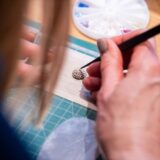 Ein Teilnehmer formt und bearbeitet ein Schmuckstück aus Silberton während eines kreativen Workshops in Basel – inspirierendes Teamevent und Teamausflug.