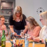 Eine Gruppe von Teilnehmern gestaltet individuelle Ringe bei einem Schmuck Workshop in Basel – kreative Teamarbeit und gemeinsamer Ausflug.