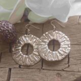 Large round silver earrings with a contemporary checkered pattern, handcrafted during a Creative Jewelry Workshop Basel and designed by a workshop participant.