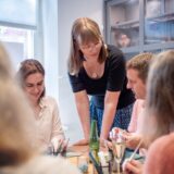 Gruppe von Teilnehmern überlegt gemeinsam beim kreativen Silberschmuck Workshop in Basel – inspirierende Teambuilding Aktivität im Atelier Mein Meisterwerk.